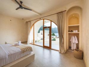a bedroom with a bed and a large window at Holista Bali in Kubupenlokan +20 photos
