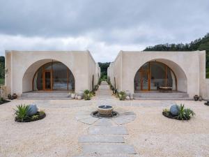 a stone house with two arches and a courtyard at Holista Bali in Kubupenlokan