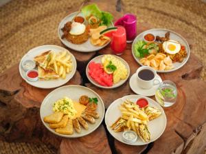 a wooden table with plates of food on it at Holista Bali in Kubupenlokan