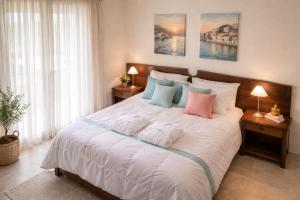 a bedroom with a large white bed with pillows at Makis Inn Resort in Thermisía +59 photos