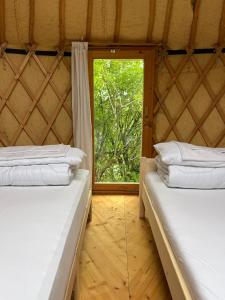 two beds in a room with a window at Pilgerhaus Wildsteig in Wildsteig
