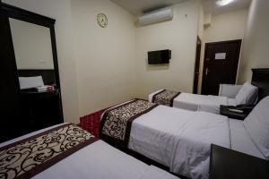 A bed or beds in a room at Qasr Zuwar Hotel
