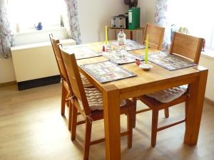 a dining room table with four chairs and a wooden table at Ferienwohnung Sauer in Wöhrden