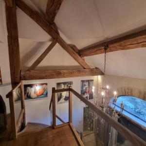 a staircase in a room with a ceiling with wooden beams at La Grange à Nicolas in Baume-les-Messieurs