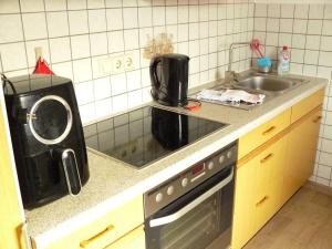 a kitchen with a sink and a microwave at Ferienwohnung Sauer in Wöhrden
