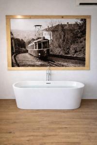 a bath tub in a bathroom with a picture of a train at Chalet Al bosco incantato in Trieste
