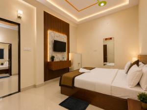 a bedroom with a large bed and a television at Radhe Shyam Resort Vrindavan By HRG Hotel Near Prem Mandir in Vrindāvan