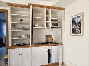 a kitchen with white cabinets and a sink at "Zweisam" am Scharmützelsee - Ferienwohnung mit mediterranem Charme in Diensdorf-Radlow