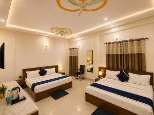 a hotel room with two beds and a television at Radhe Shyam Resort Vrindavan By HRG Hotel Near Prem Mandir in Vrindāvan