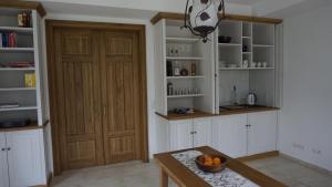 a kitchen with white cabinets and a wooden door at "Zweisam" am Scharmützelsee - Ferienwohnung mit mediterranem Charme in Diensdorf-Radlow