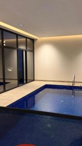 a large swimming pool in a building with at منتجع شاطئ الدانة Hus Chalet in Dammam