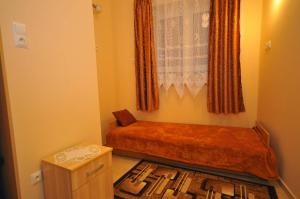 a small bedroom with a bed and a window at Apartament U Jacka in Rabka-Zdrój