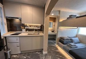 a small kitchen with a sink and a couch at Billy Hostel in Busan +44 photos
