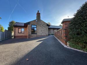 a brick house with a brick wall and a driveway at Havendale in Chesterfield