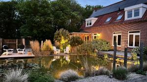 a garden with a pond in front of a house at Het Pauwtje in Zoutelande