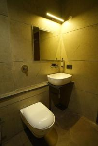 a bathroom with a white toilet and a sink at Hotel manju श्री in Pachmarhī