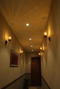 a hallway with lights on the ceiling and a door at Hotel manju श्री in Pachmarhī