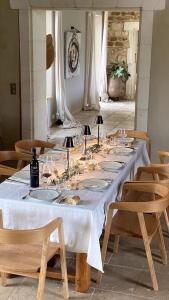 a long table with a white table cloth and chairs at A charming Provençal farmhouse in Mouriès