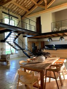 a dining room with a wooden table and stairs at A charming Provençal farmhouse in Mouriès