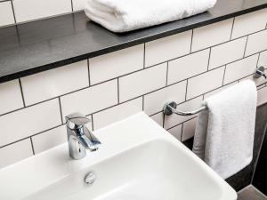a bathroom with a white sink and white towels at ibis Chartres Ouest Luce in Chartres