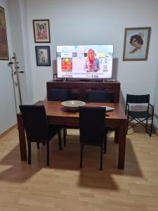 a dining room with a table and a television at Calle Cañón 9 in Cartagena