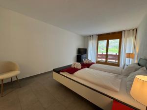 a bedroom with a large bed and a window at Eiger Residence 1 in Wengen
