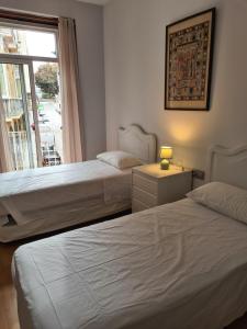 a hotel room with two beds and a window at Calle Cañón 9 in Cartagena