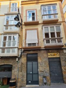 a building with windows and balconies on a street at Calle Cañón 9 in Cartagena