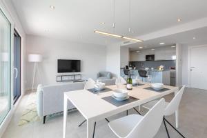 a white dining room with a white table and chairs at Doña Julia Sea View Marvel in Casares