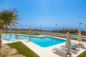 a large swimming pool with chairs and a umbrella at Doña Julia Sea View Marvel in Casares