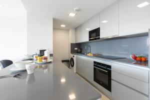 a kitchen with white cabinets and a counter top at Doña Julia Sea View Marvel in Casares