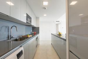 a kitchen with white cabinets and a sink at Doña Julia Sea View Marvel in Casares +26 photos