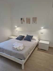 a white bedroom with a large bed with blue pillows at NonSoloCitta' in Torrette