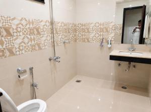 a bathroom with a shower and a toilet and a sink at 430 Elite Reside in Islamabad