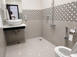 a white bathroom with a sink and a toilet at 430 Elite Reside in Islamabad