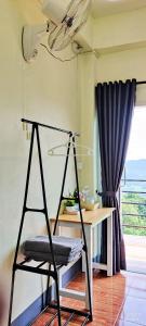 a swing in a room with a table and a window at สบายดีโฮมสเตย์ภูลังกา in Ban Sakoen +1 photo