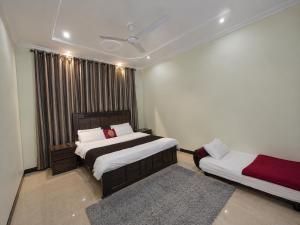 a bedroom with two beds and a rug at 430 Elite Reside in Islamabad