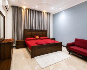 a bedroom with a red bed and a red couch at 430 Elite Reside in Islamabad +6 photos