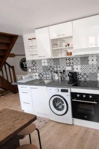 a kitchen with a sink and a washing machine at Le chalet Mountain-style duplex 6 people in Meulan