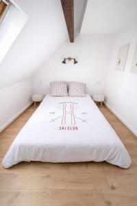 a bedroom with a white bed in a attic at Le chalet Mountain-style duplex 6 people in Meulan