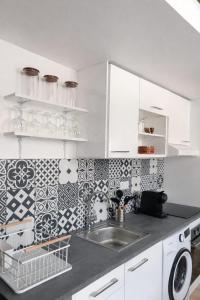 a kitchen with white cabinets and a sink at Le chalet Mountain-style duplex 6 people in Meulan