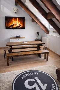 a living room with a table and a fireplace at Le chalet Mountain-style duplex 6 people in Meulan