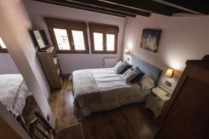 a bedroom with two beds and two windows at El Mirador in Cudillero