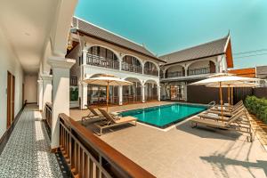 a house with a swimming pool and two umbrellas at The Jam Central in Luang Prabang