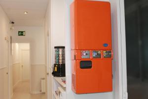 an orange refrigerator is on the wall in a room at Hostal Abitum Madrid in Madrid