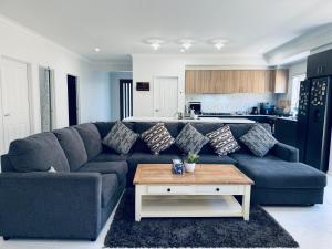 a living room with a blue couch and a coffee table at Feels Like Home in Wyndham Vale