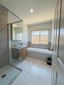 a bathroom with a shower and a sink and a tub at Feels Like Home in Wyndham Vale