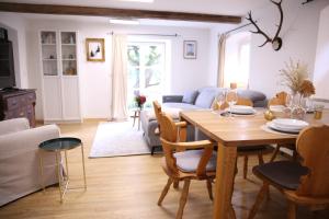 a living room with a wooden table and chairs at Ferienwohnung Oswald mit Garten im EG in Kochel