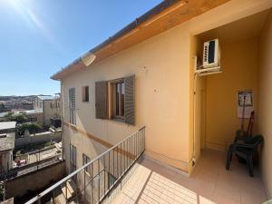 a balcony of a building with a window and a chair at La casa di nonna Gianna in Gonnesa