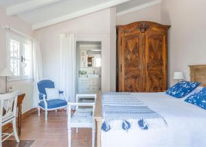 a bedroom with a bed and a desk and a chair at la maison des Olivettes in Uzès +19 photos